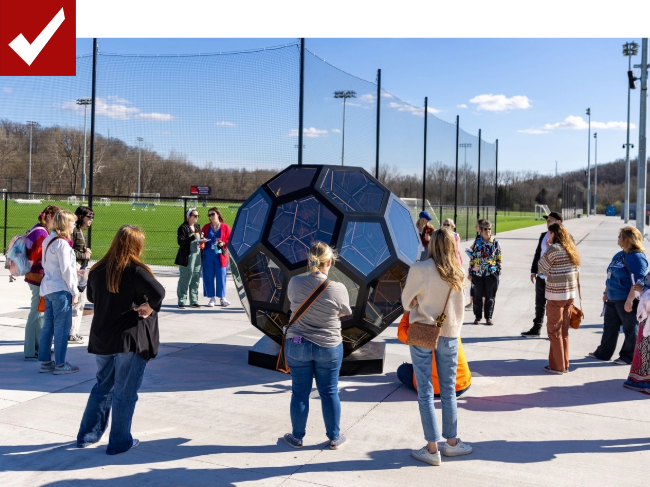 crowd looking at art sculpture
